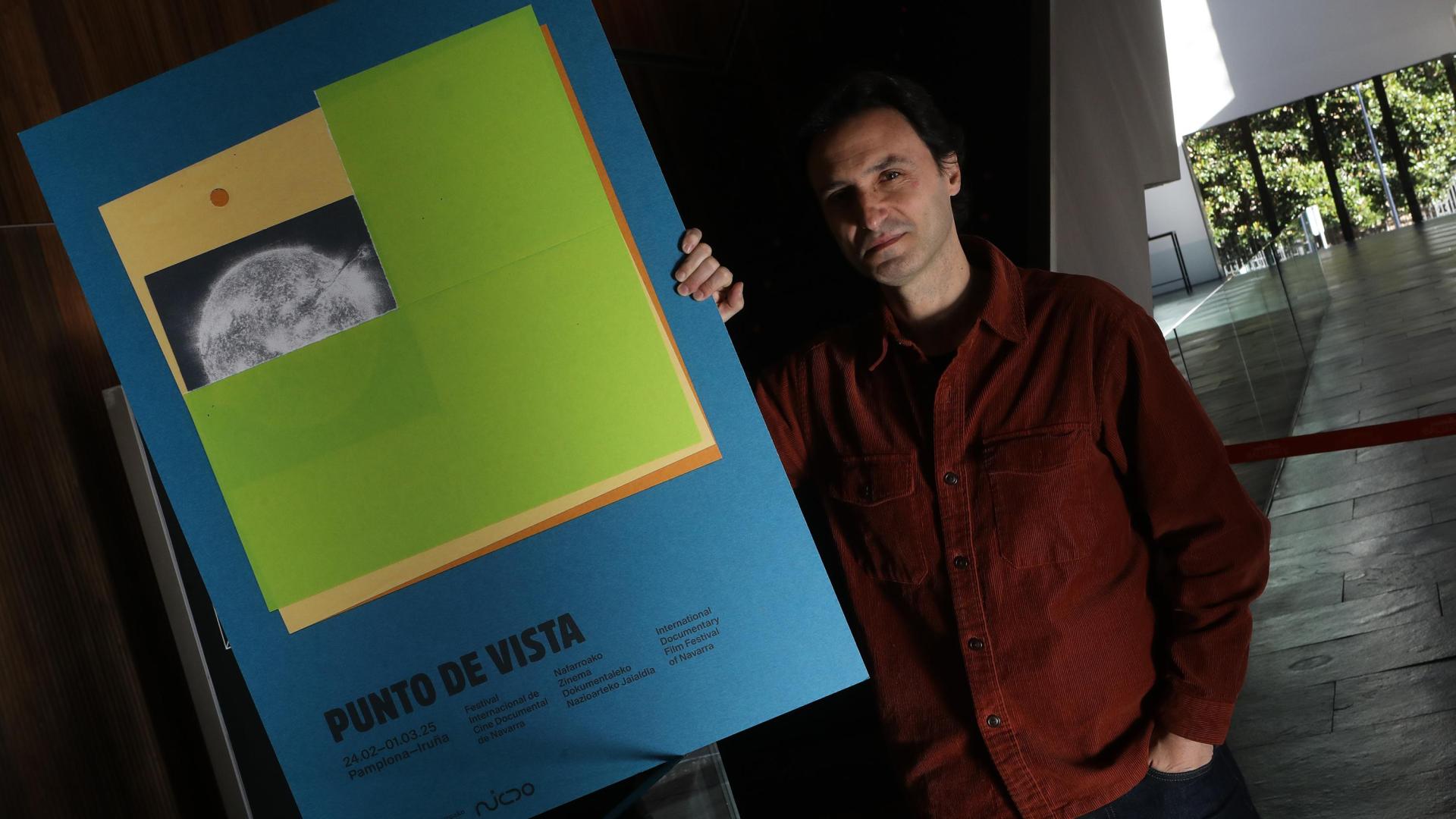 El director artístico de Punto de Vista, Manuel Asín, con uno de los carteles de este año, obra de la artista Magdalena Orellana