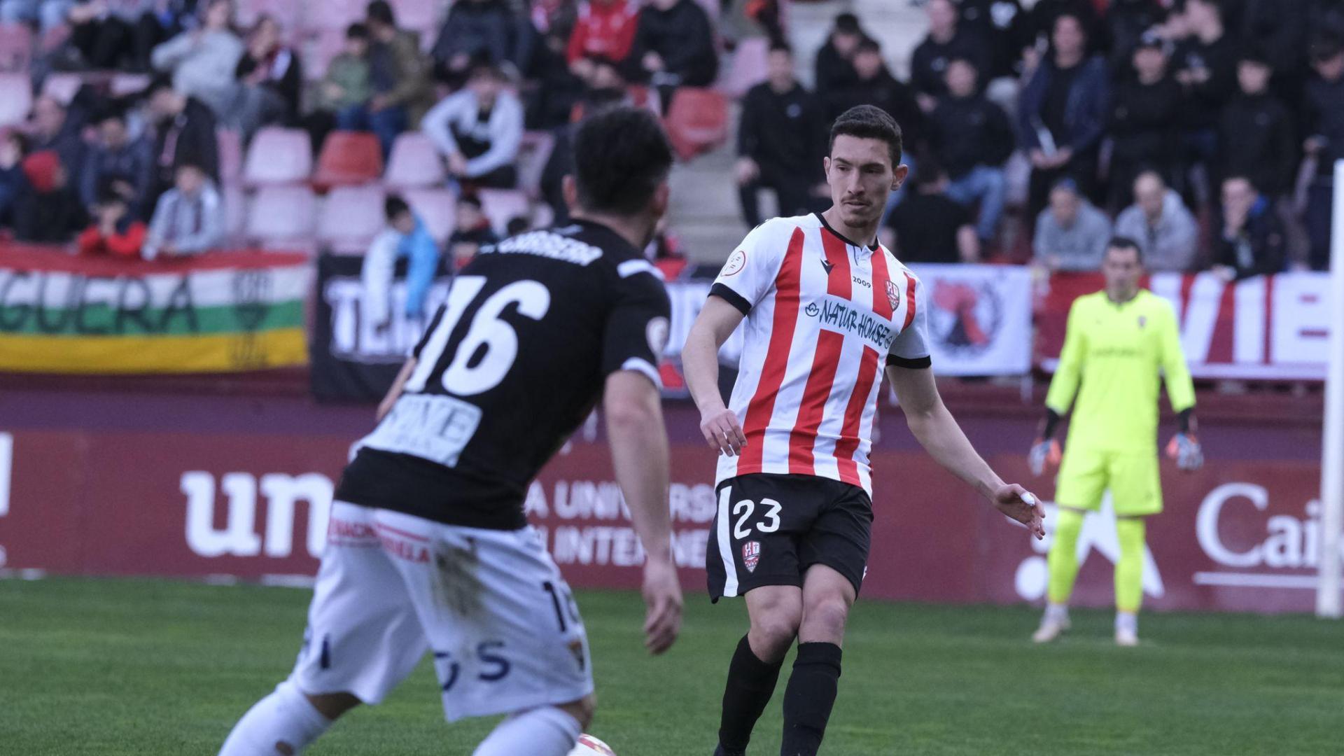 Joao, de la UDL, trata de dar un pase ante la presencia de Lluc Carrera, del Tudelano