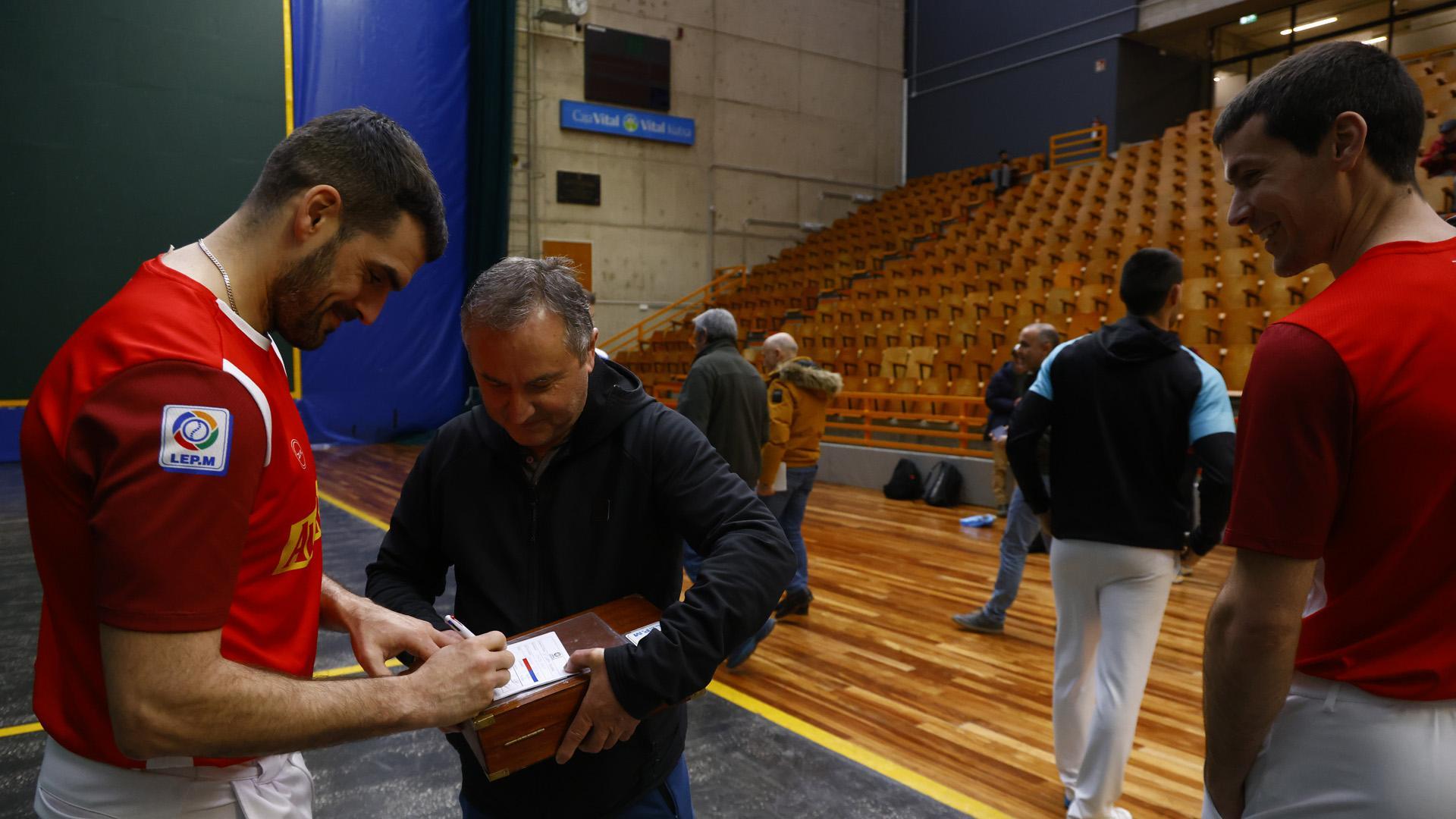 Joseba Ezkurdia estampa su firma sobre el maletín que contiene las pelotas del primer partido de semifinales en el frontón Ogueta