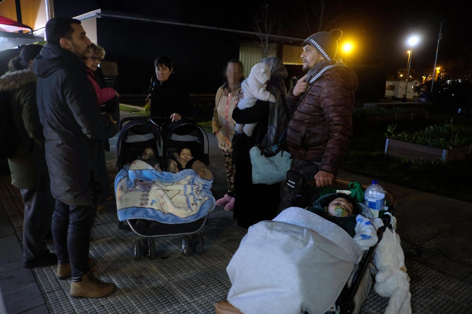 Dos de las cuatro familias, el miércoles por la noche con sus bebés en la puerta del albergue.