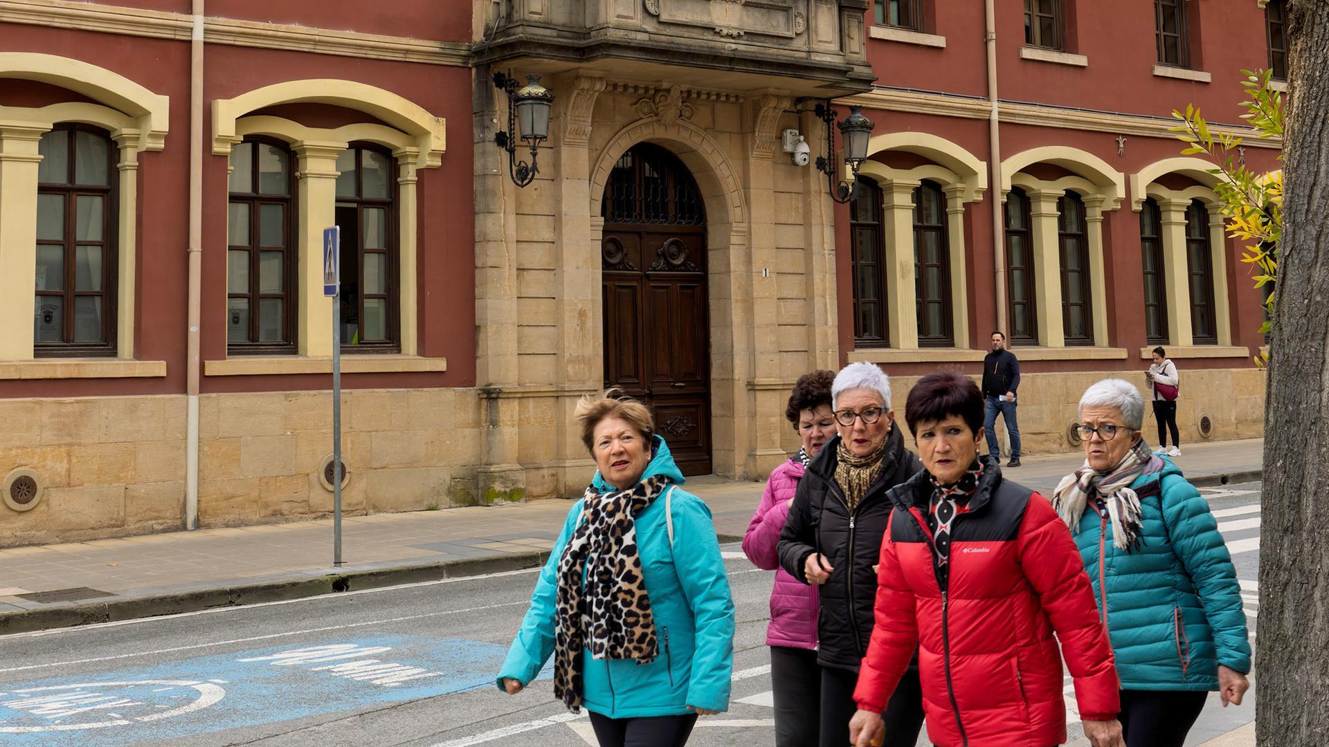 Grupo de viandantes y, al fondo, el  Ayuntamiento de Estella