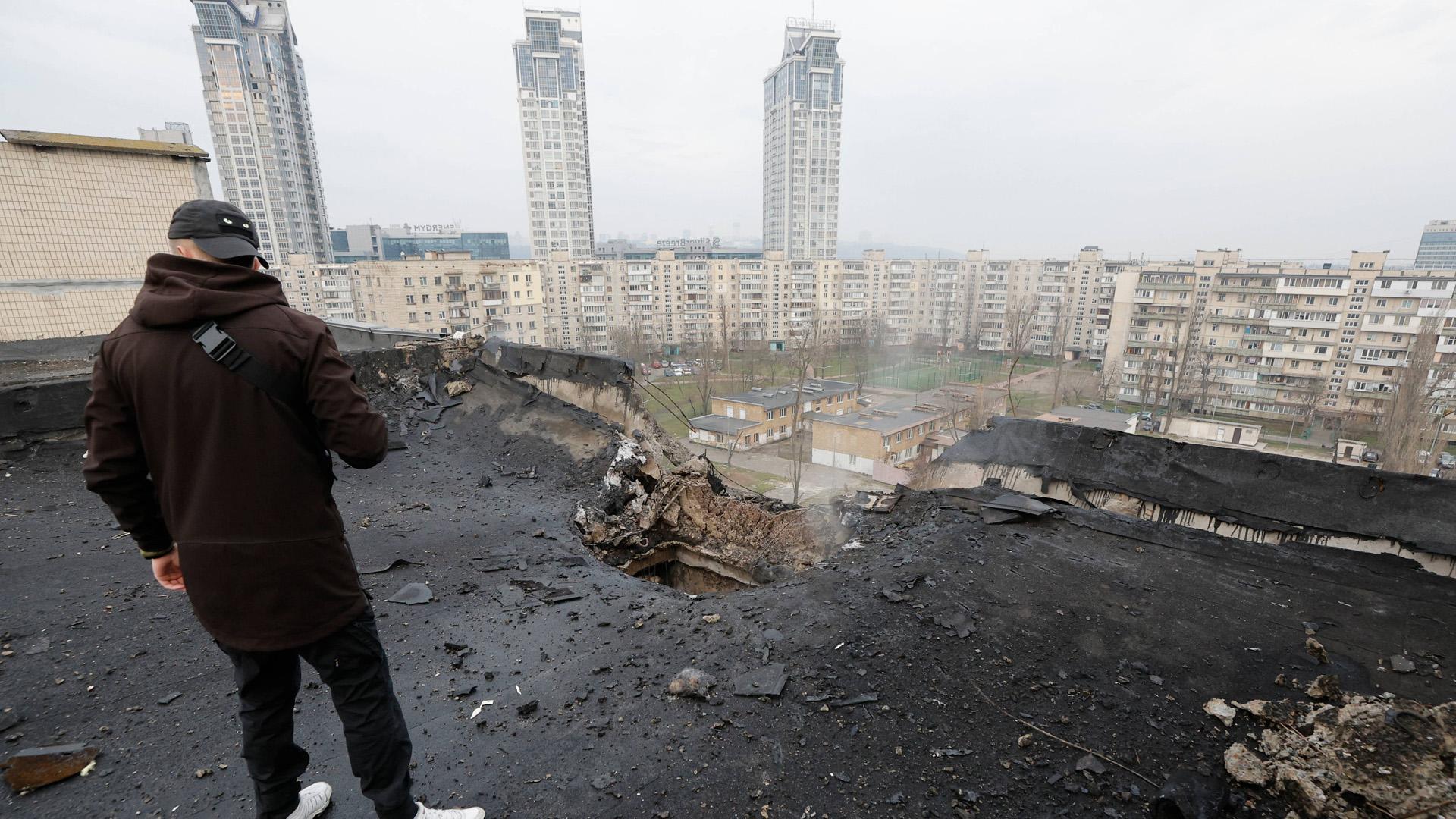 Un hombre inspecciona los daños causados por un ataque nocturno de drones en el tejado de un edificio residencial en Kiev