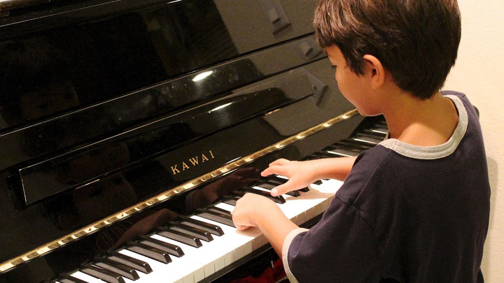 Un niño aprendiendo a tocar el piano
