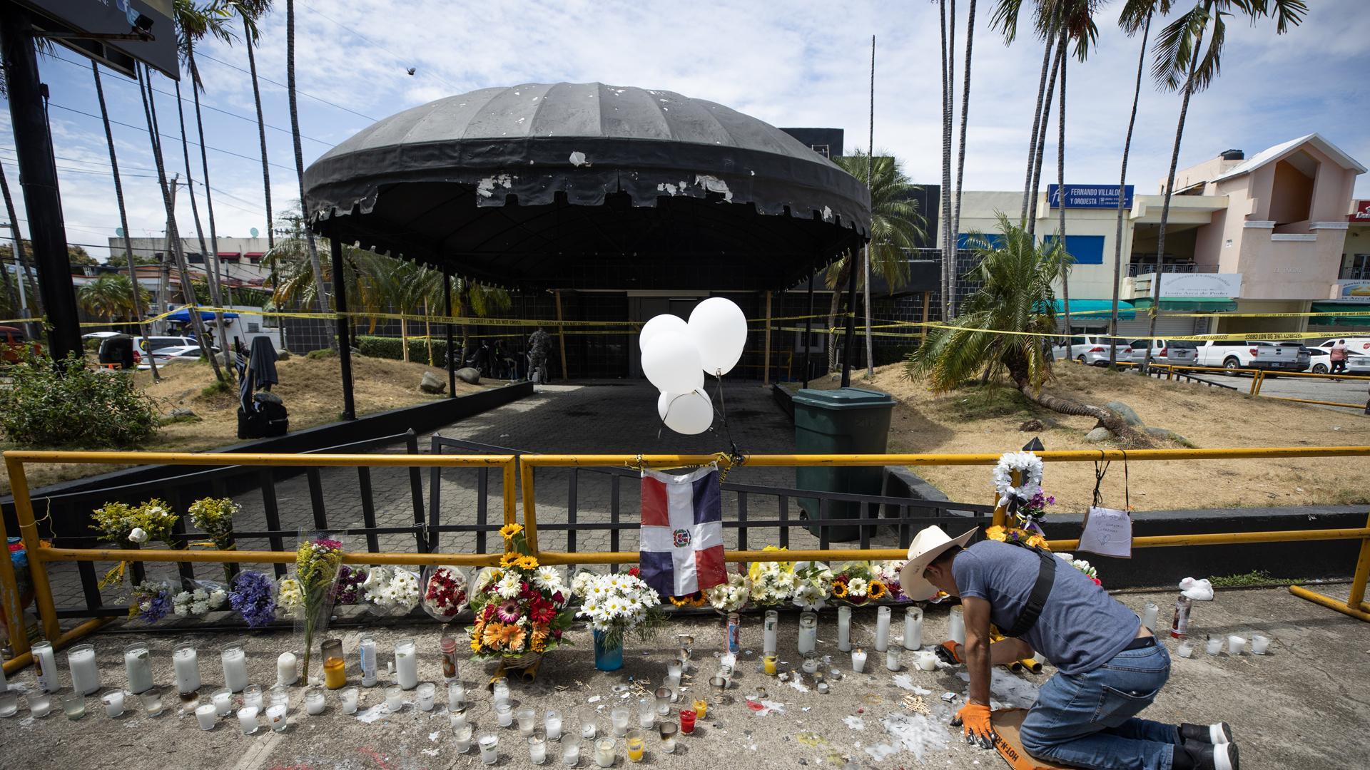 Un hombre enciende velas en la entrada de la discoteca Jet Set, en Santo Domingo (República Dominicana)