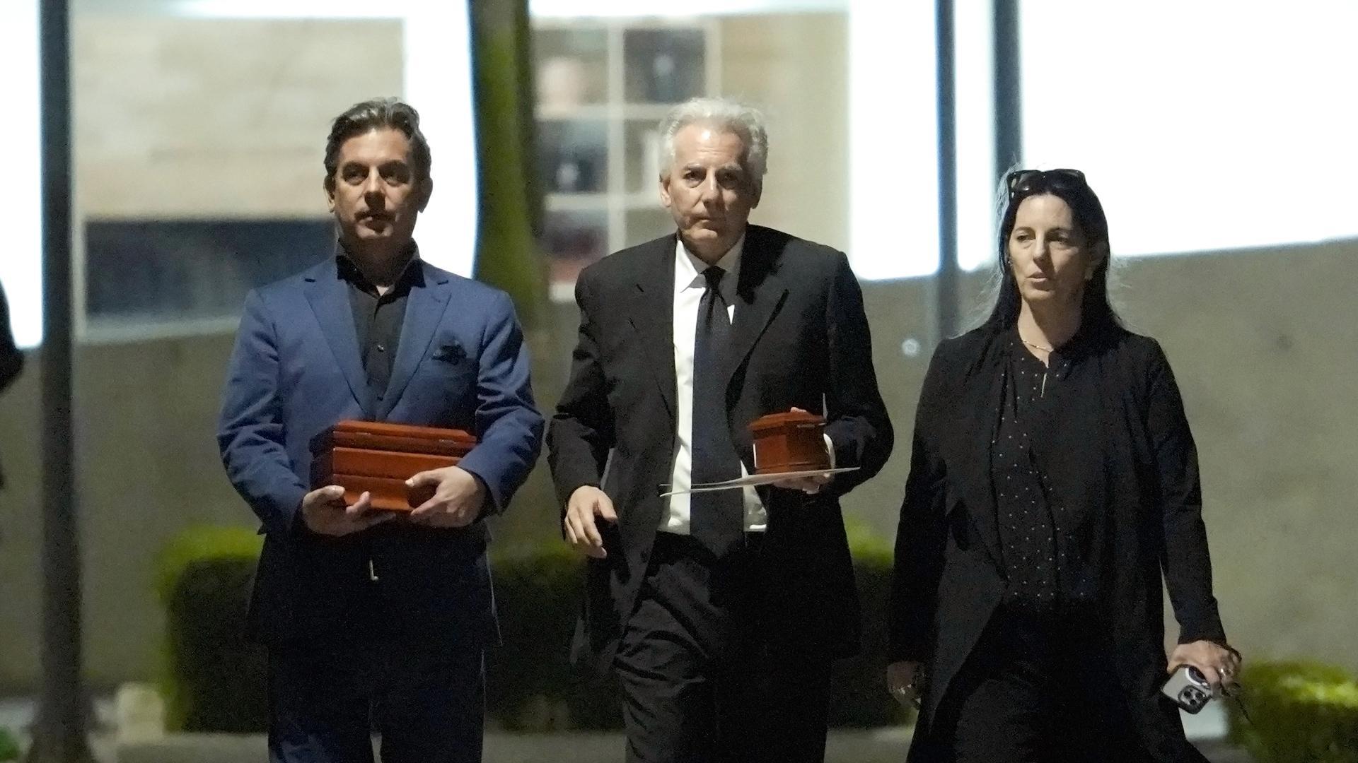 De izquierda a derecha, Gonzalo Vargas Llosa, Álvaro Vargas Llosa, y Morgana Vargas Llosa, hijos del escritor peruano Mario Vargas Llosa, caminan portando dos urnas con los restos de su padre