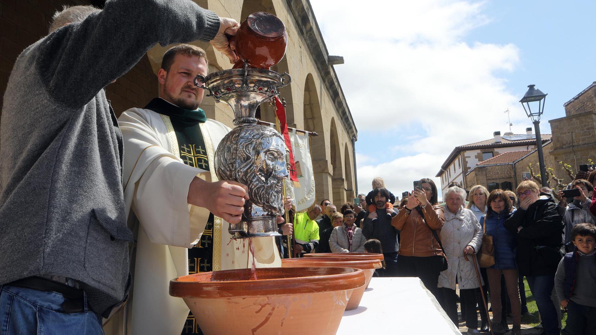El párroco Damián Ranachowski sujetando la reliquia de plata que cubre el cráneo de San Guillén para bendecir el vino y el agua