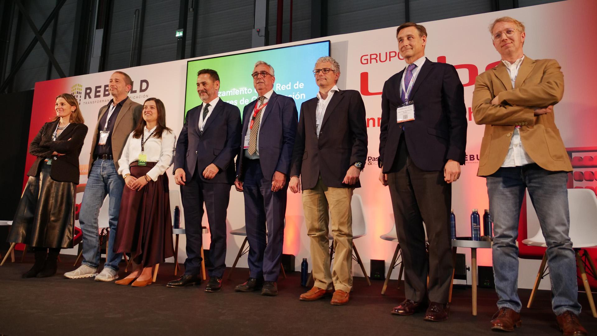 Los presidentes de AEICE, Estíbaliz González; CCIC, Pere Armora; la directora de BuildInn, Marta Epelde; junto a los presidentes del Clúster de la Edificación, Juan Antonio Gómez; CICA, Juan Carlos Bandrés; Galicia Constrúe, Diego Freire; de ICONS, Íñigo Eugui; y de ARIC, Ismael Martín en el acto de constitución de la Red de Clústeres de la Construcción en Rebuild 2025.