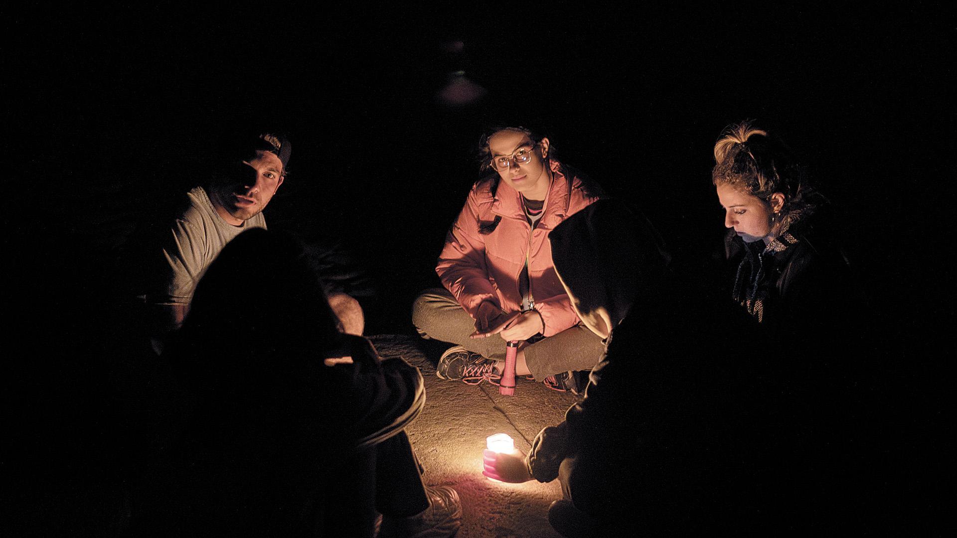 Un grupo de peregrinos se alumbra con una vela en la plaza del Obradoiro de Santiago de Compostela