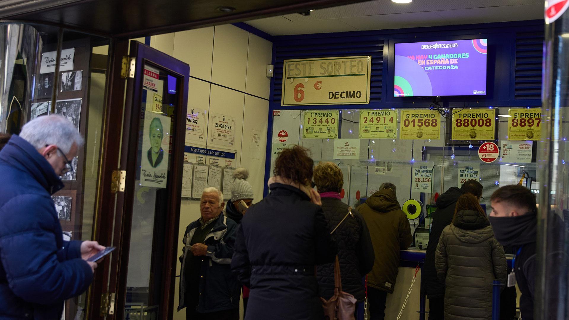 Personas comprando décimos en una administración de loterías de Madrid