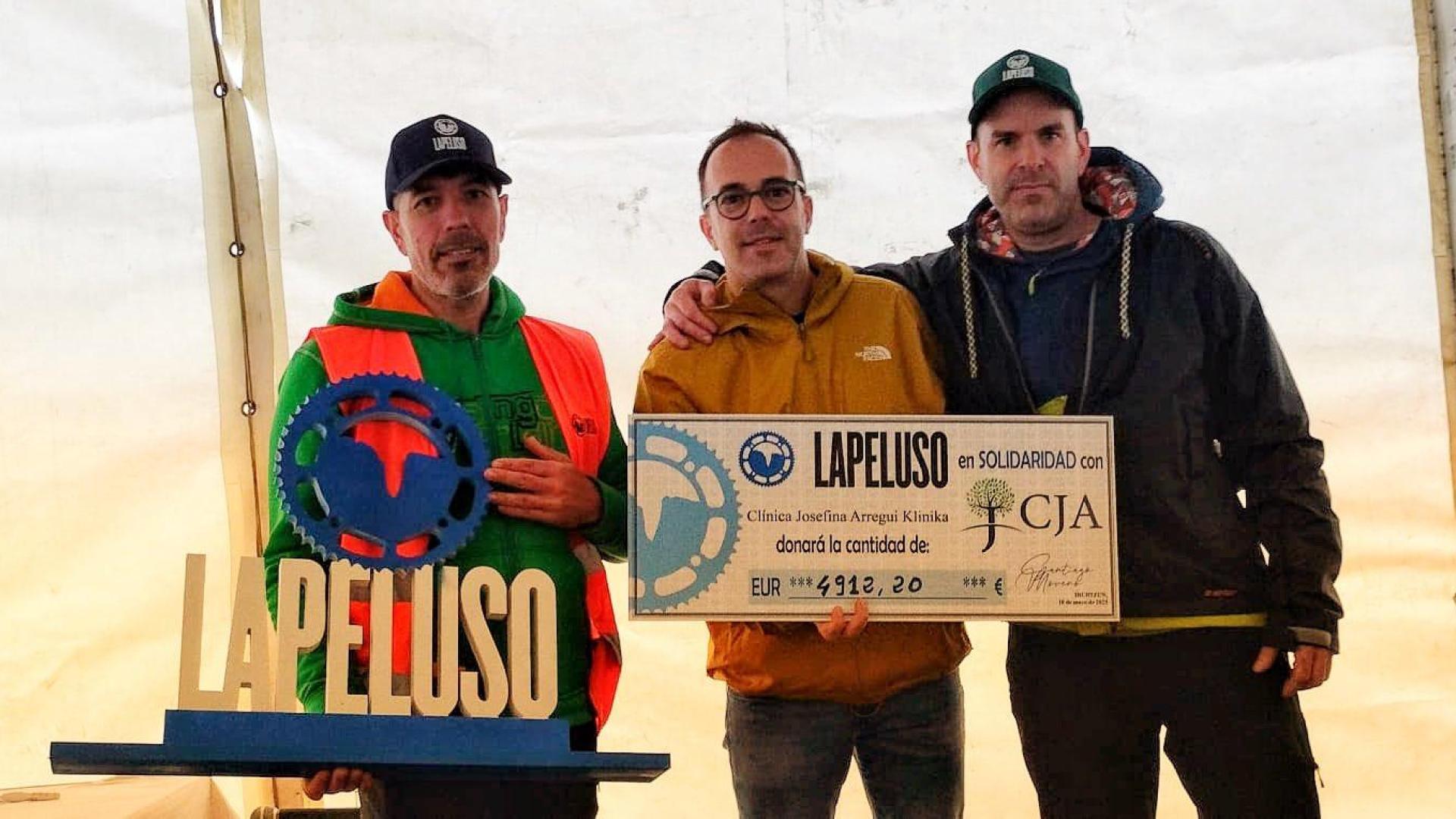 Los responsables de La Peluso, con el representante de Josefina Arregui, y la donación que han hecho los participantes.