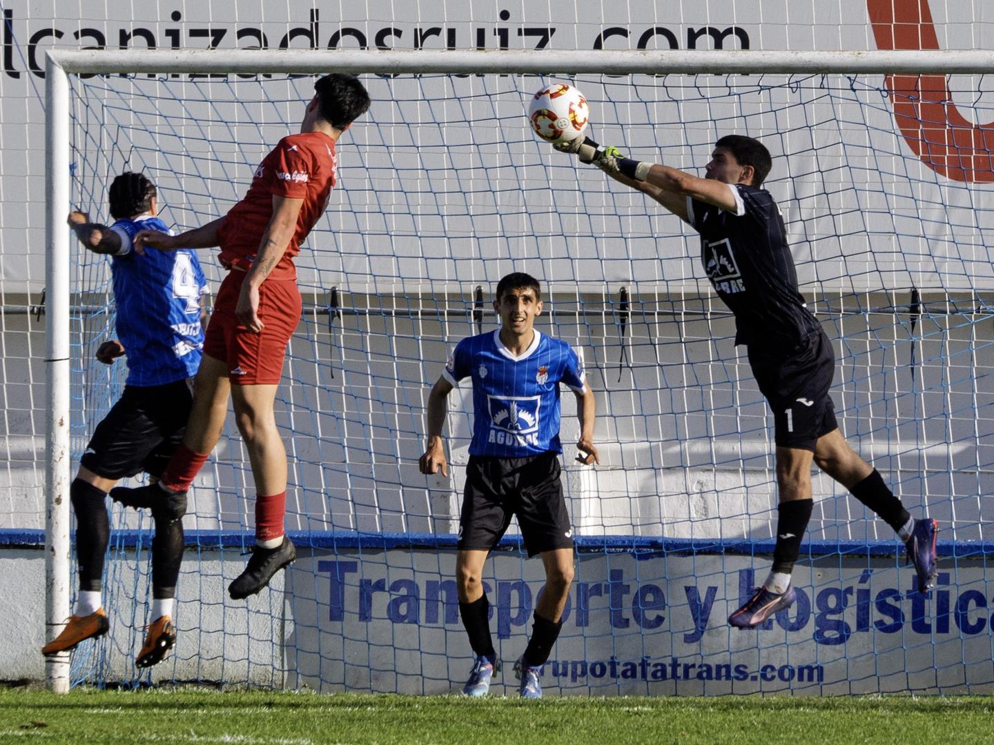 El guardameta de la Peña Sport, Adrián Tabuenca, despeja un cabezazo de Goikoetxea