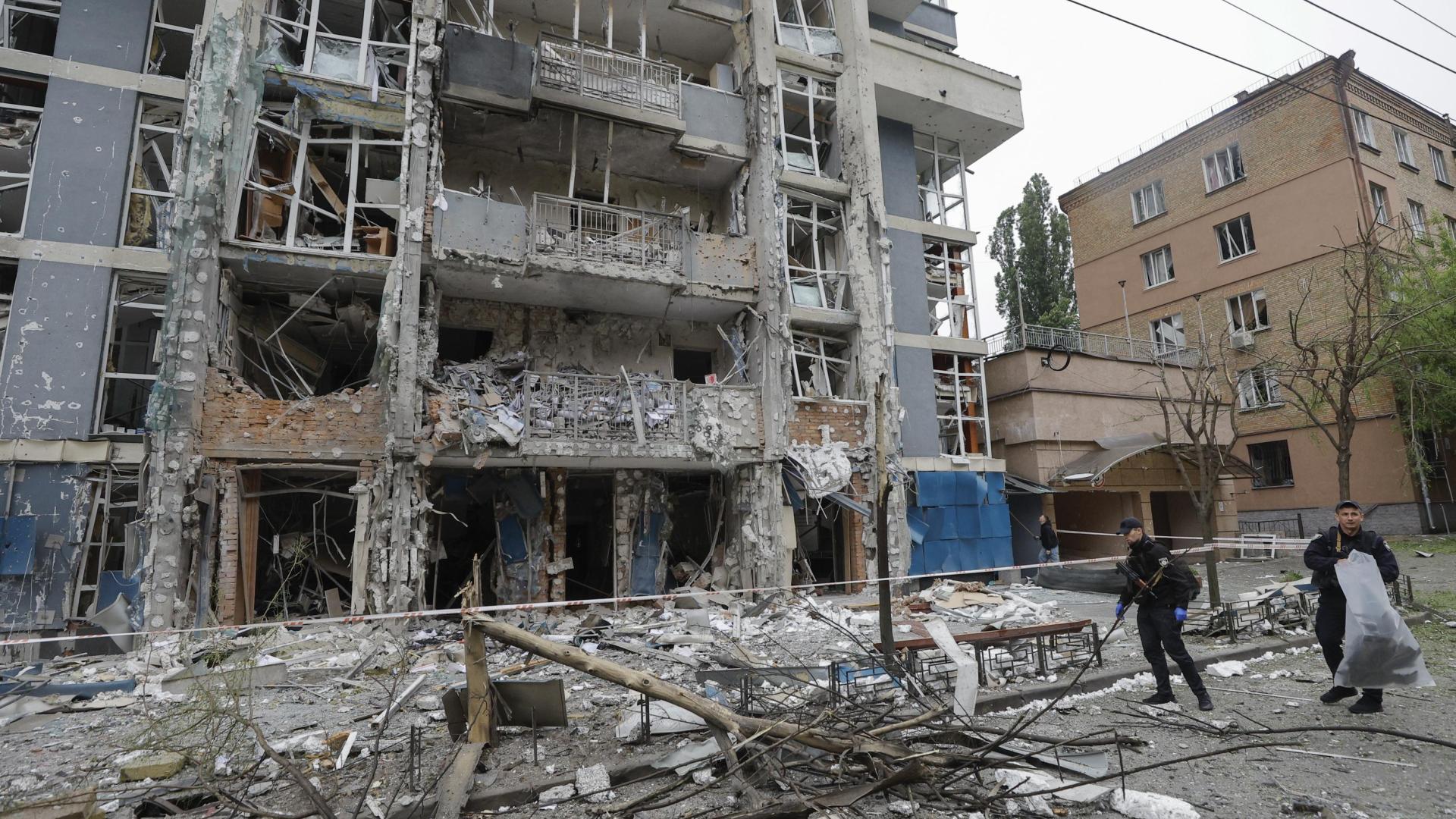 Expertos ucranianos trabajan junto a un edificio derruido por drones en Kiev