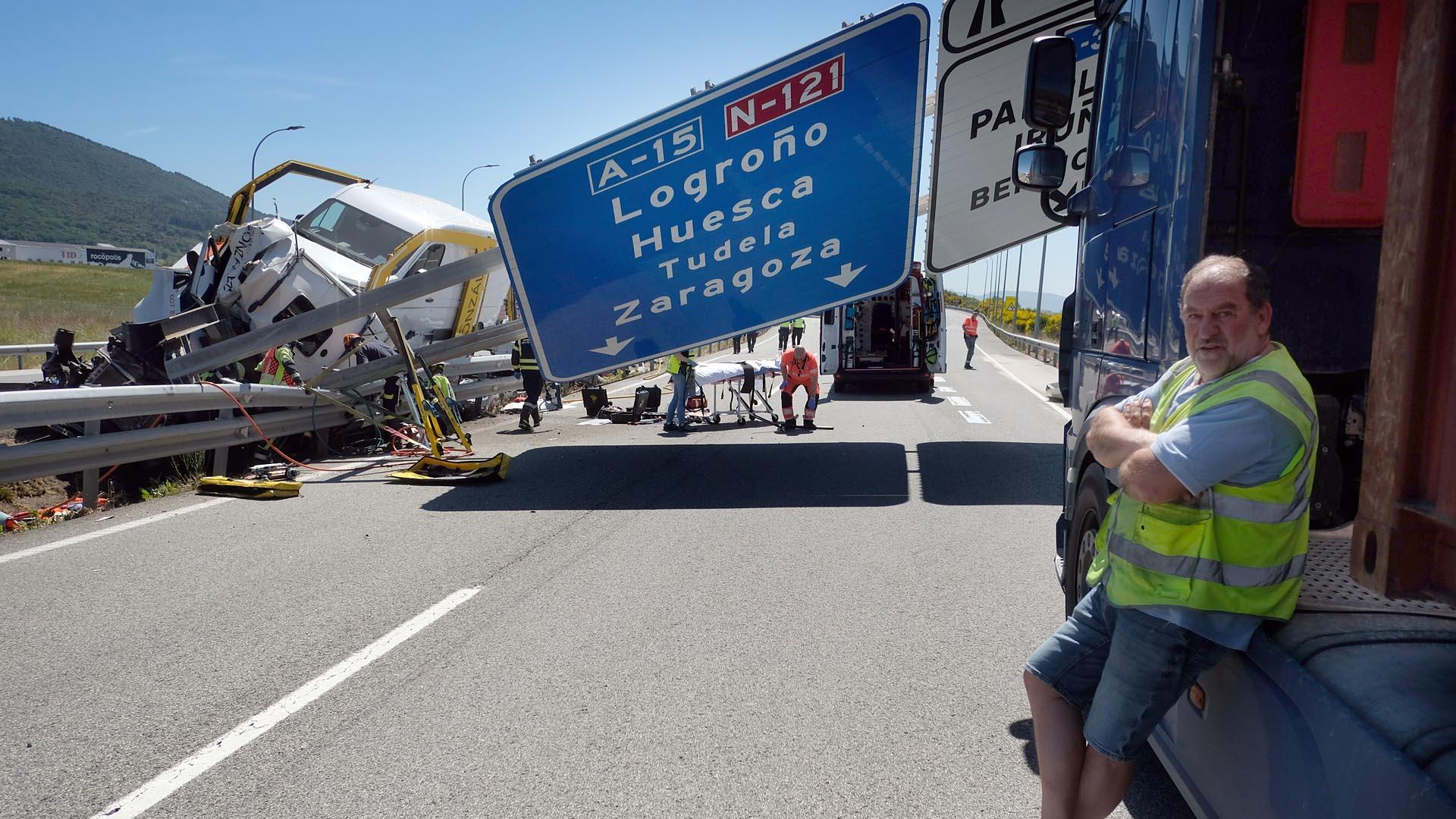 En primer plano, el camionero que casi choca con la señal de la autopista