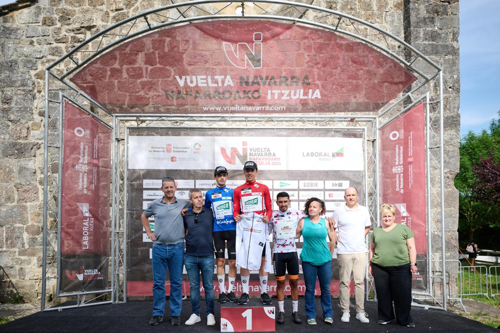 Iker Gómez, líder de la Vuelta Navarra, flanqueado por Unai Ramos y Óscar Daniel Tellez en la ermita de Itxasperri