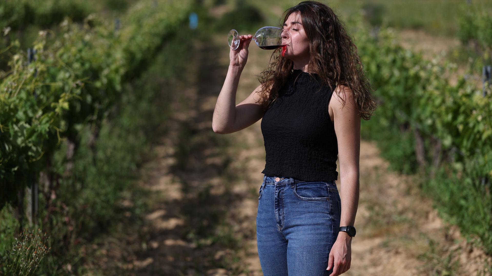 Sara Valencia sostiene una copa de su vino ‘G de Genaro’ en una de sus viñas de San Martín de Unx