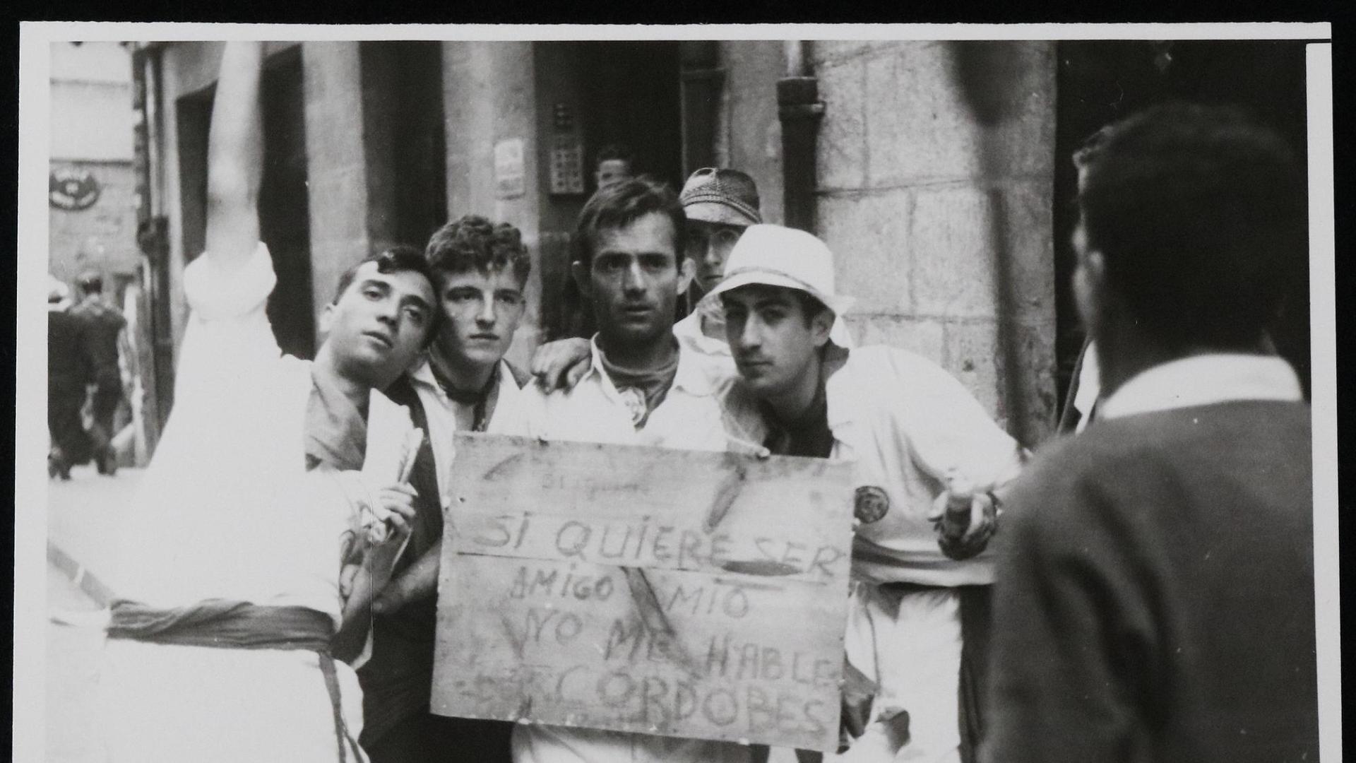 Unos mozos en los Sanfermines de 1965 con un cartel que dice: "Si quiere ser mi amigo, no me hable del Cordobés"