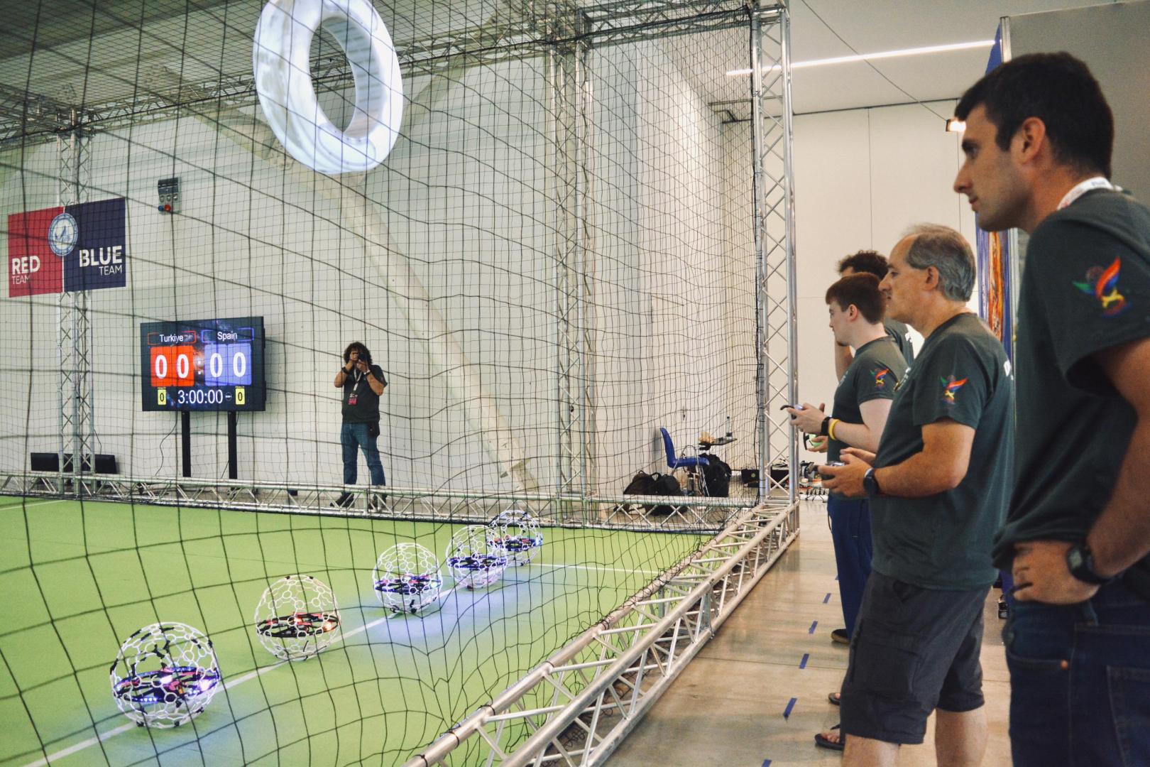Desde fuera de la red, los equipos manejan sus drones con mandos