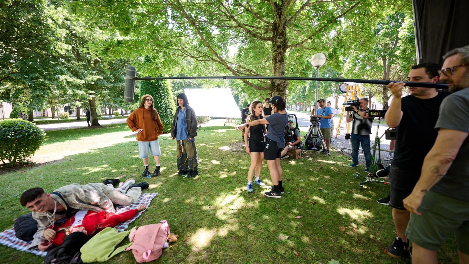 Lorena Iglesias, tumbada de rojo, con el el actor Daniel Vitallé, ruedan una secuencia de Millennial Mal, en el campus de la UPNA. Les observan las actrices Victoria Oliver (con boina) y Paula Gala. Y su lado, la codirectora Andrea Jaurrieta con Sara San Martín, ayudante de dirección