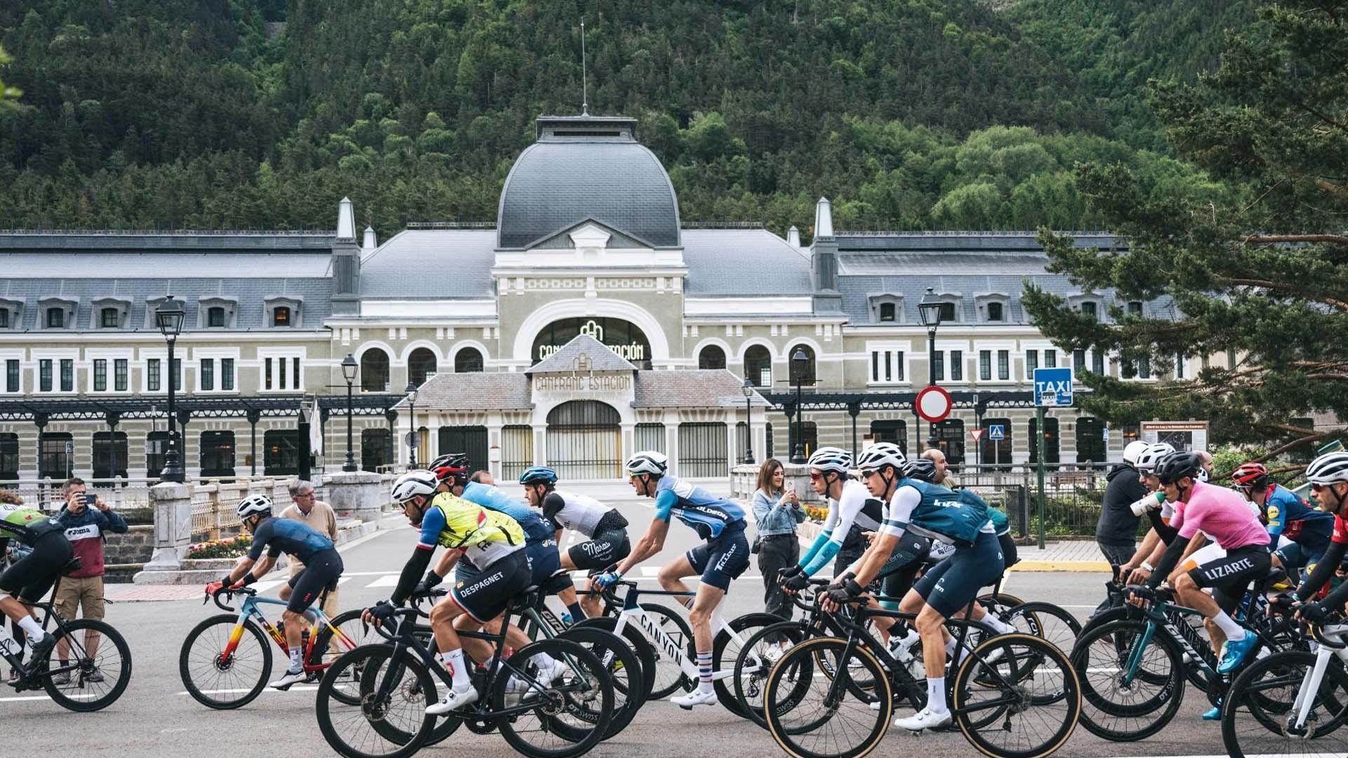 Ciclistas de la Quebrantahuesos pasan ante la antigua estación de tren de Canfrac