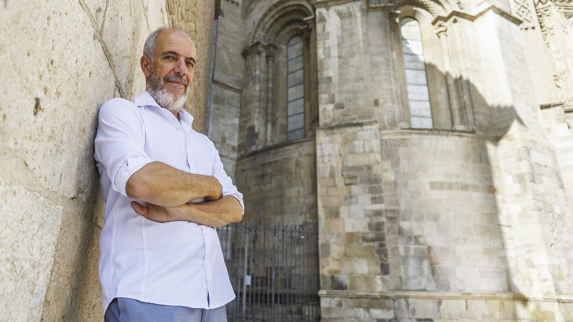 El doctor en Historia del Arte José Luis García Lloret posa ante la parte románica del ábside de la Seo del Salvador de Zaragoza /