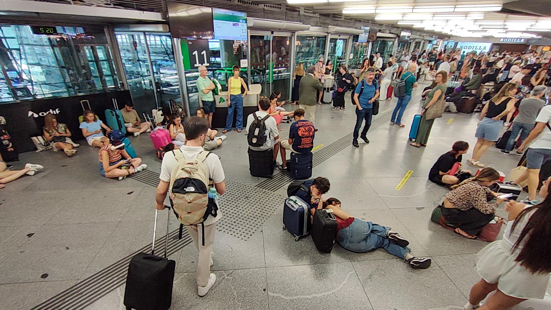 Cientos de personas esperan la salida de su tren en la estación de Atocha en Madrid