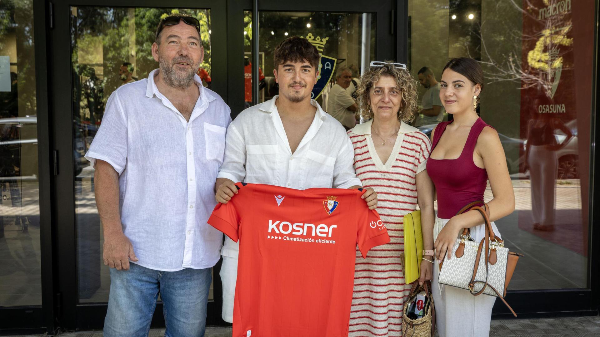 Joan Lega, con su camiseta rojilla junto a su familia nada más recibirla