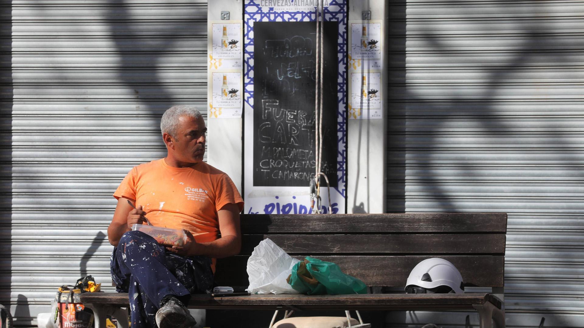 Un trabajador descansa en un banco