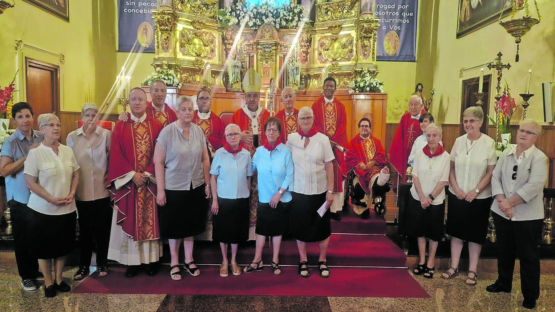 Las hermanas de las Hijas de la Caridad, con un pañuelo rojo junto al arzobispo y los sacerdotes que le acompañaron en la misa