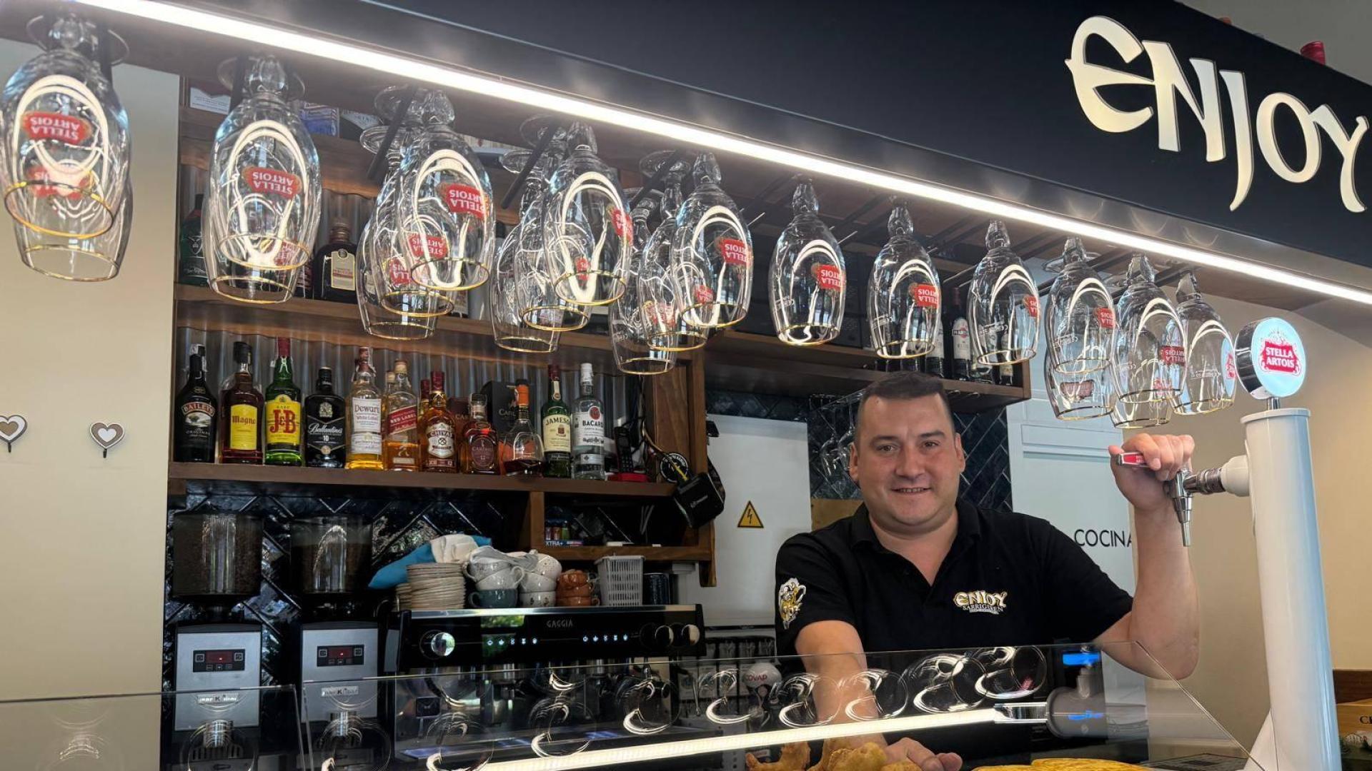 Ángel Dequel Erro, dueño del bar Enjoy en Sarriguren, posa con los cañeros de la barra y pintxos tradicionales