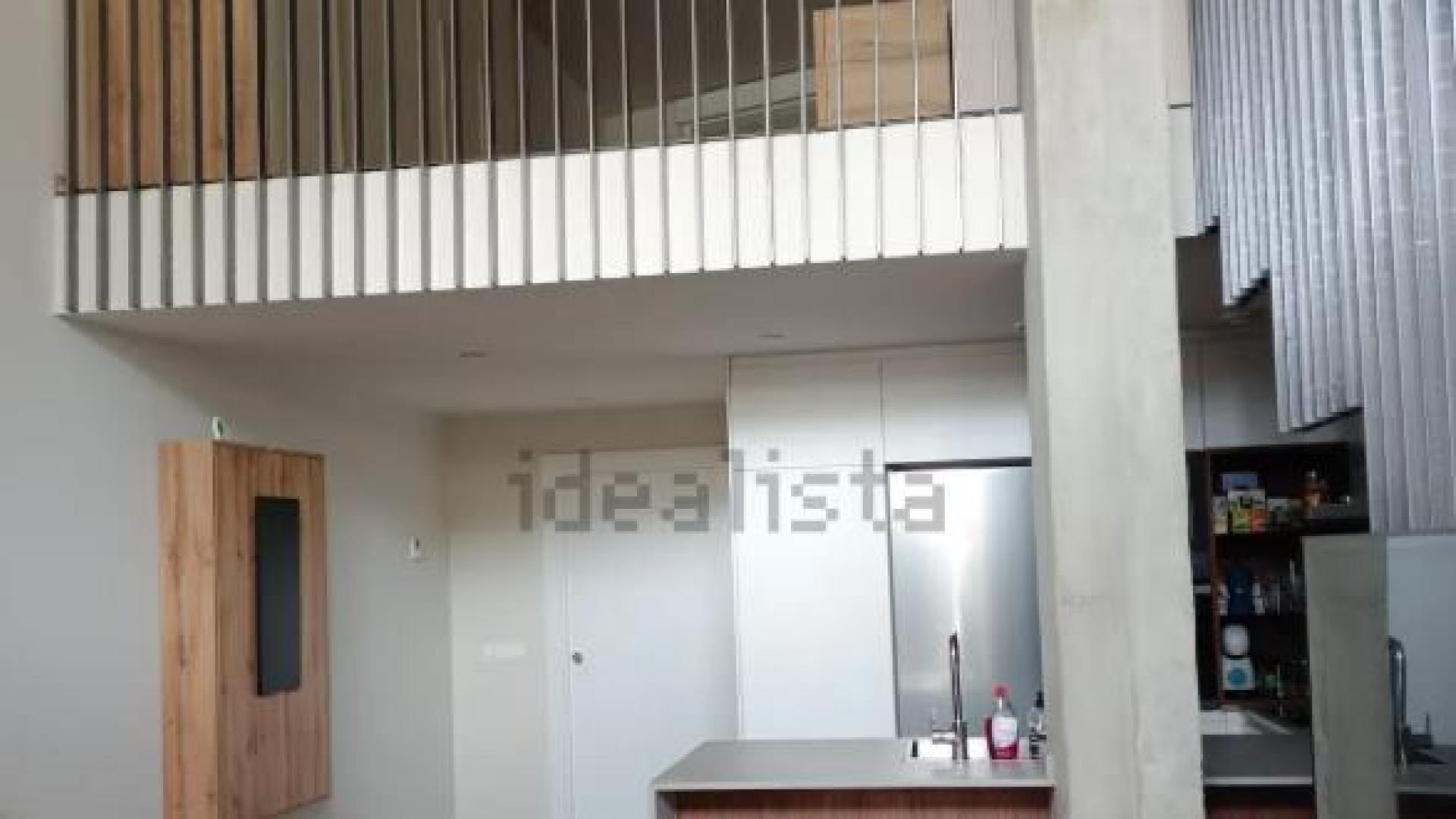 Cocina y salón bajo la sobreplanta del loft disponible en Arrosadía