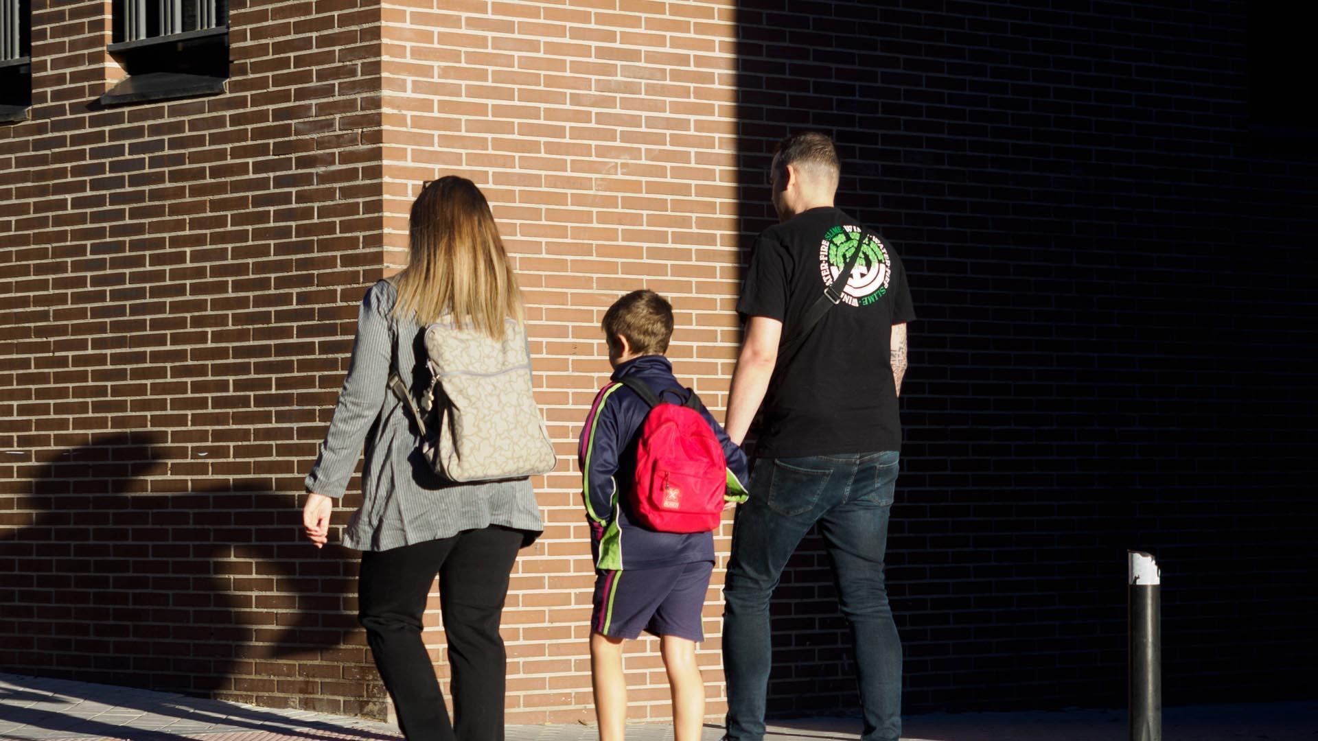 Una pareja lleva a su hijo al colegio en Madrid