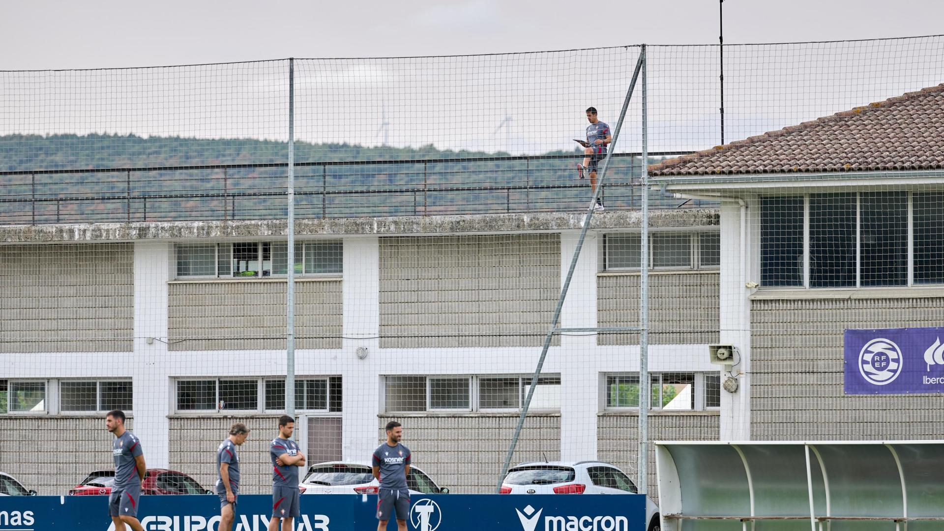 El analista Joan García sigue desde lo alto de Tajonar uno de los entrenamientos de Osasuna, con Gianluca Troilo, Chema Sanz, Alessio Lisci y Darío Navarro en el césped. j.p. urdíroz