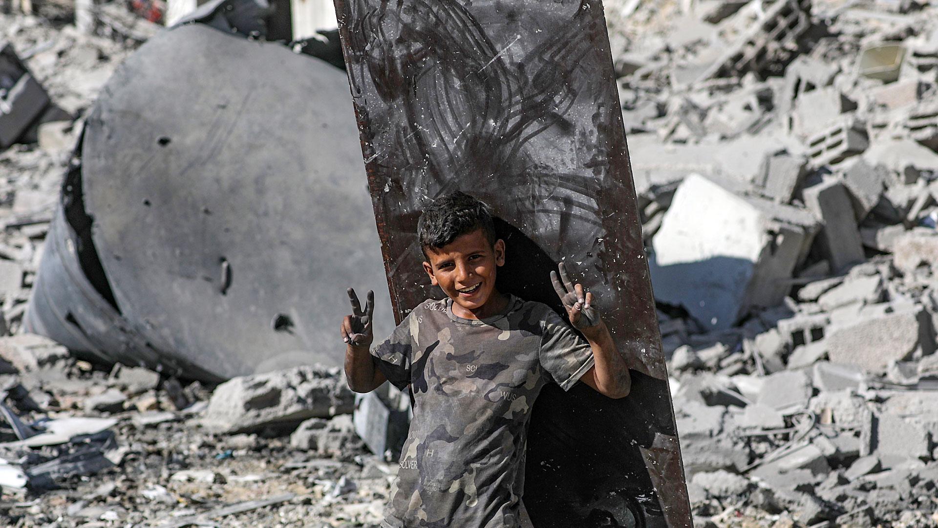 Un niño palestino sonríe este viernes entre los escombros de las viviendas en ciudad de Gaza