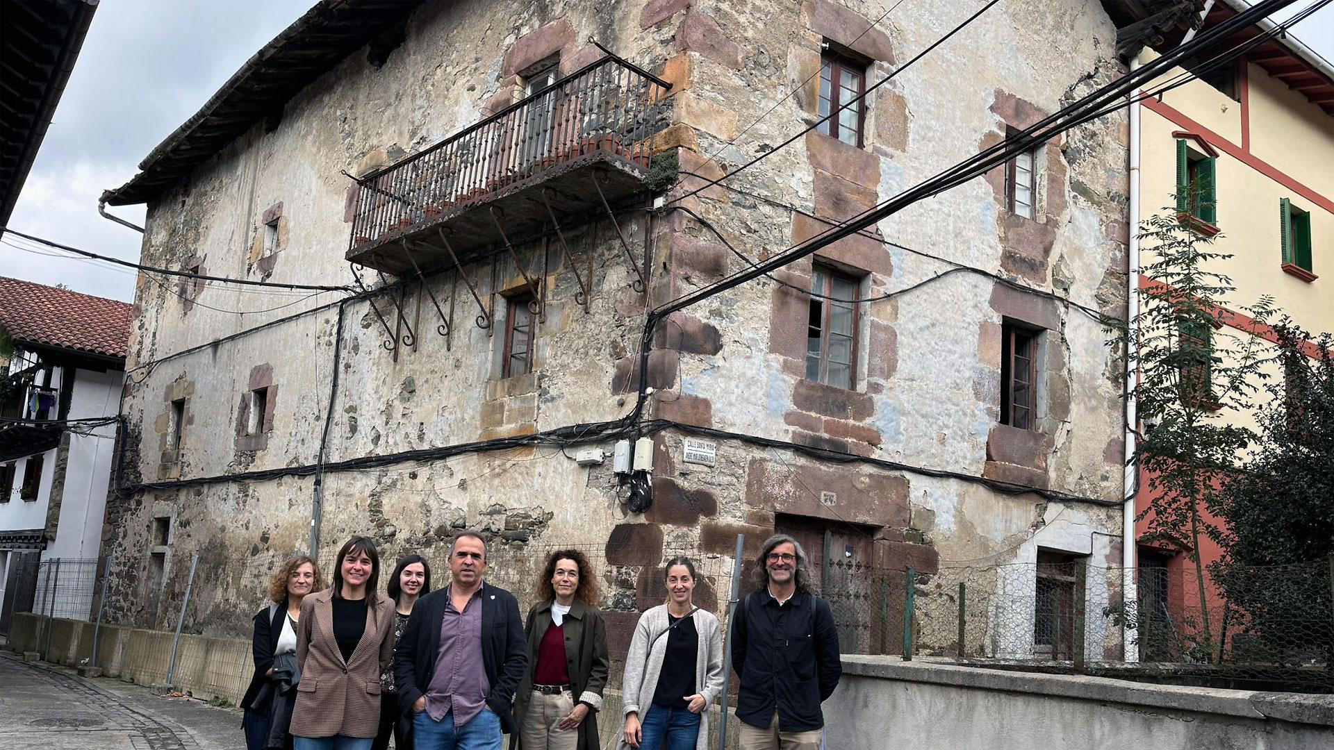 La vicepresidenta Begoña Alfaro y el alcalde de Goizueta, Unai Miranda, junto a ediles de la localidad y personal técnico de rehabilitación, delante del inmueble que se va a acondicionar