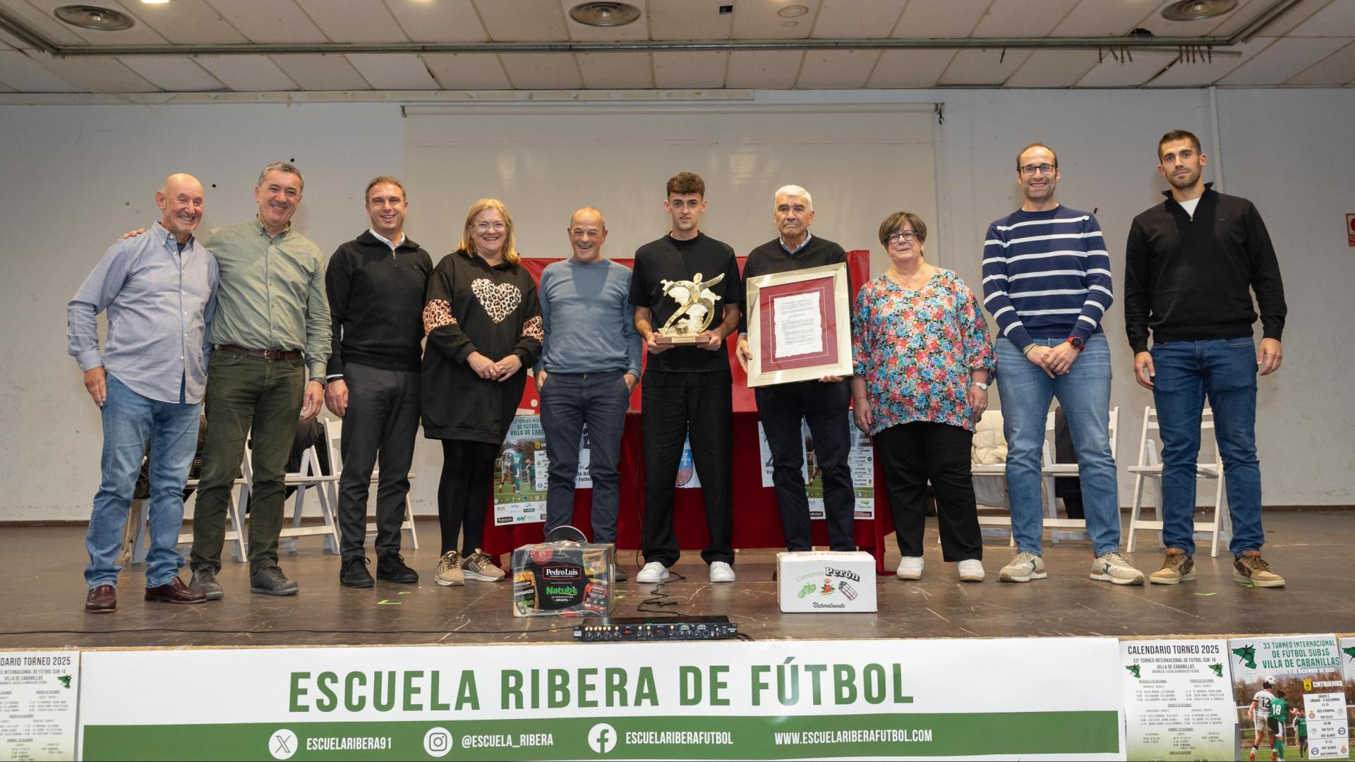 HOMENAJE A AIMAR OROZ El jugador de Osasuna Aimar Oroz, en el centro de la imagen, recibido ayer el premio de la Escuela Ribera de Fútbol. En la foto, de izda. a dcha.: Luis González ‘El Jabonero’, José Luis Sanz, Óscar Bea, Inma Ciriza, José Mª Pastor, Aimar Oroz, Chus Rodríguez, Raquel Paz, Jorge Aguirre, y Uriel Arellano