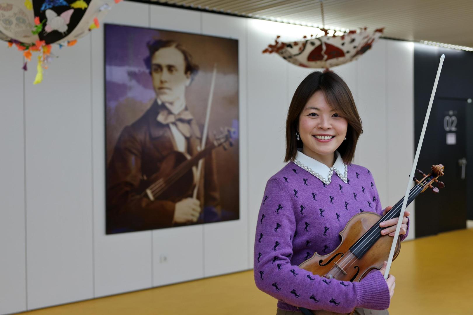 Jiyoon Lee sujeta su violín en el Conservatorio Profesional de Música Pablo Sarasate, ante una imagen del músico pamplonés