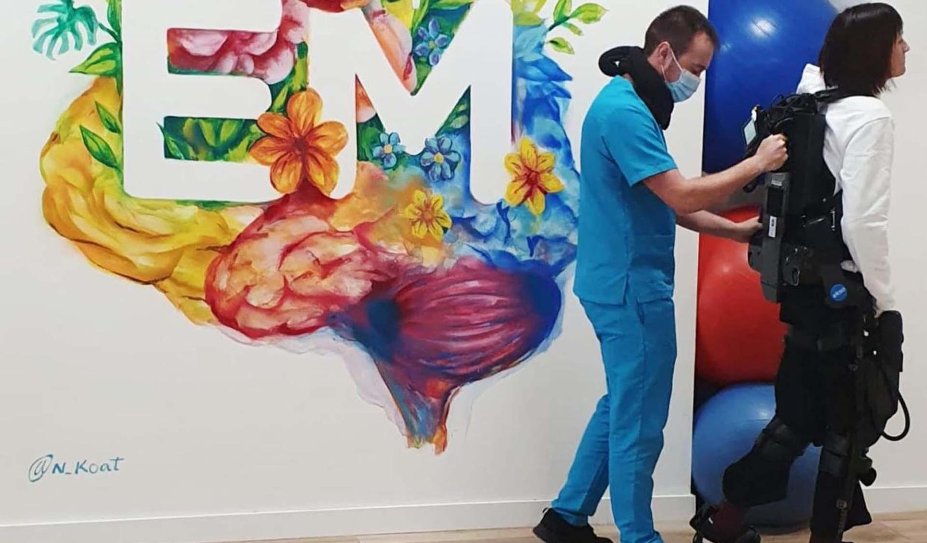 Una persona utiliza el exoesqueleto con las indicaciones de un fisioterapeuta