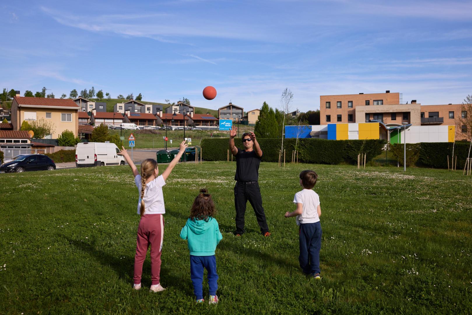 Txikis y adultos juegan en una zona verde de Olloki, mayor población por habitantes de Esteribar
