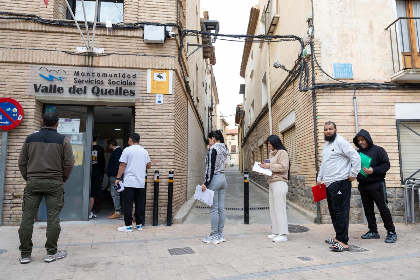 Varios inmigrantes esperan a la puerta de la sede de la Mancomunidad de Servicios Sociales Valle del Queiles, ubicada en Cascante