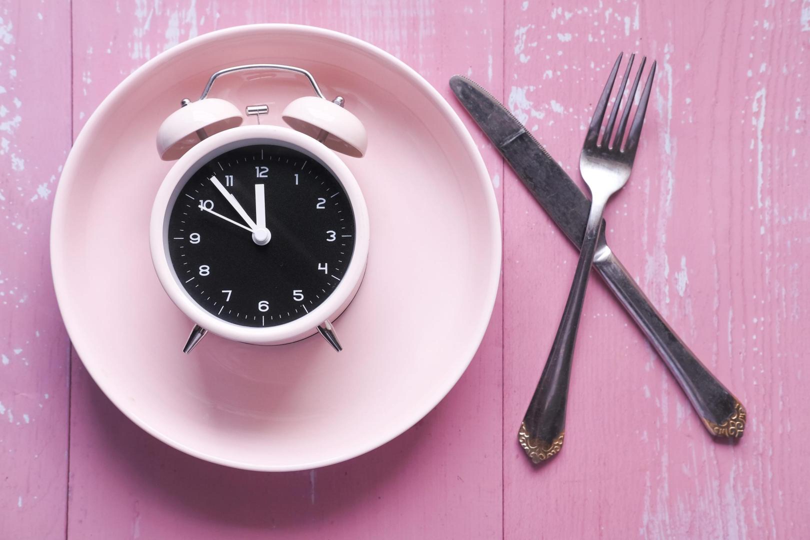the concept of Healthy Food, alarm clock on plate