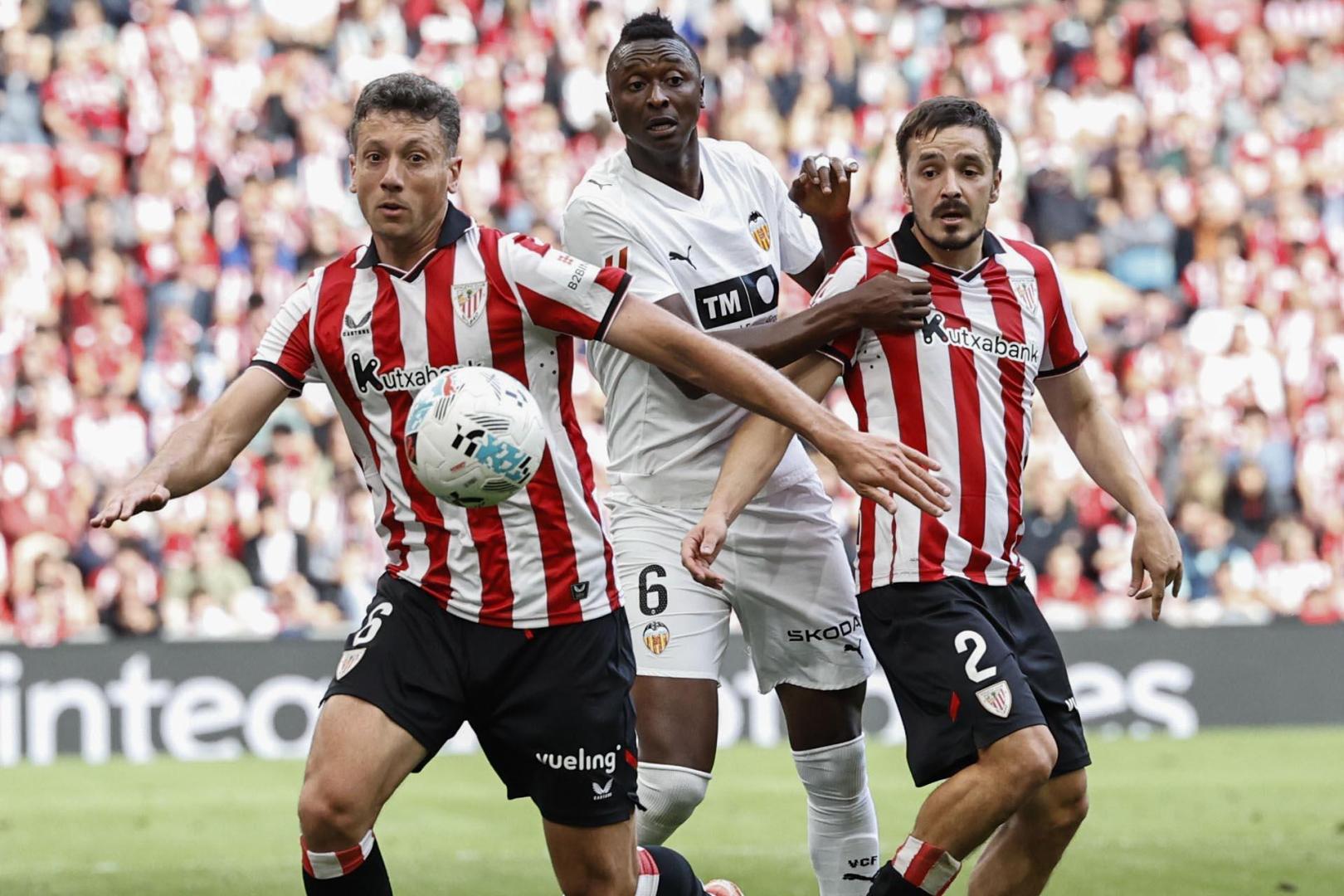 El delantero nigeriano del Valencia Umar Sadiq, autor del gol de su equipo, disputa el balón ante Andoni Gorosabel y Mikel Vesga, del Athletic