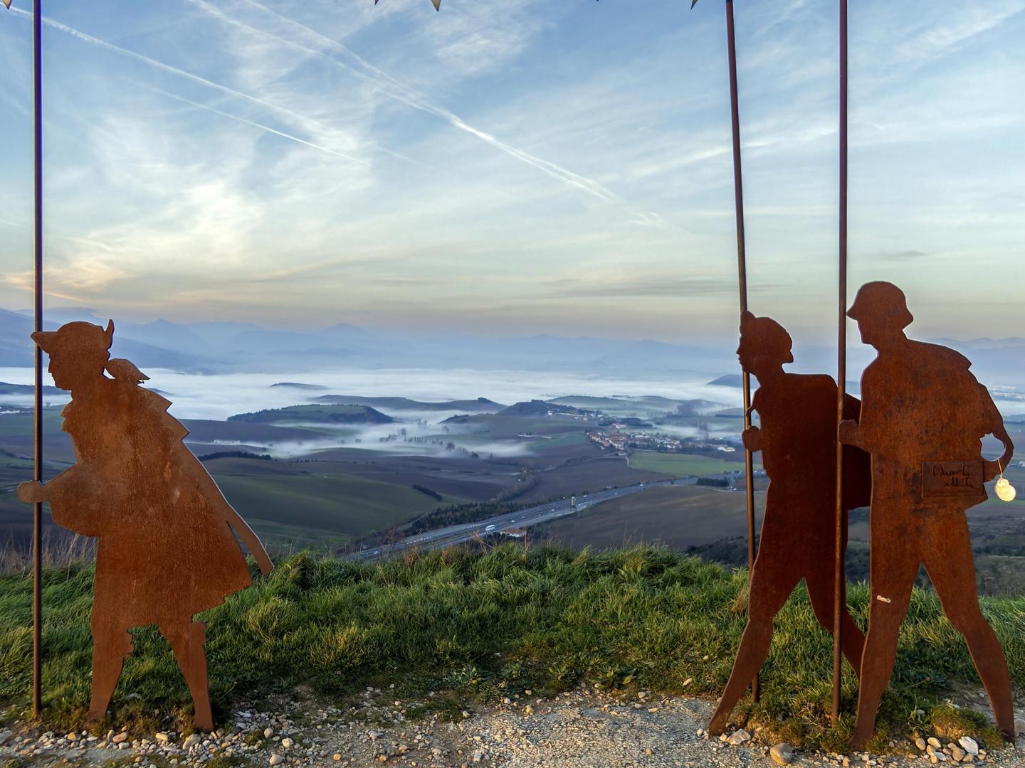Las siluetas de los caminantes en el alto de El Perdón-Erreniega, punto donde concluirá el ascenso de La Cizur-Gares y arrancará el descenso hacia la vertiente sur