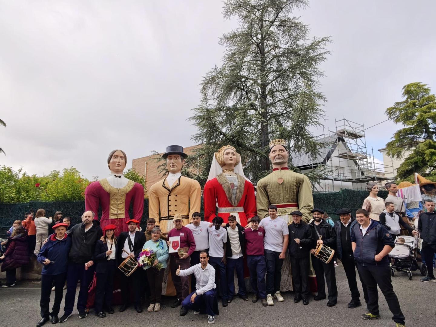Dolores Echarte Viana posa junto a la comparsa de gigantes, a la que en salidas festivas ofrecía un lunch en su tienda