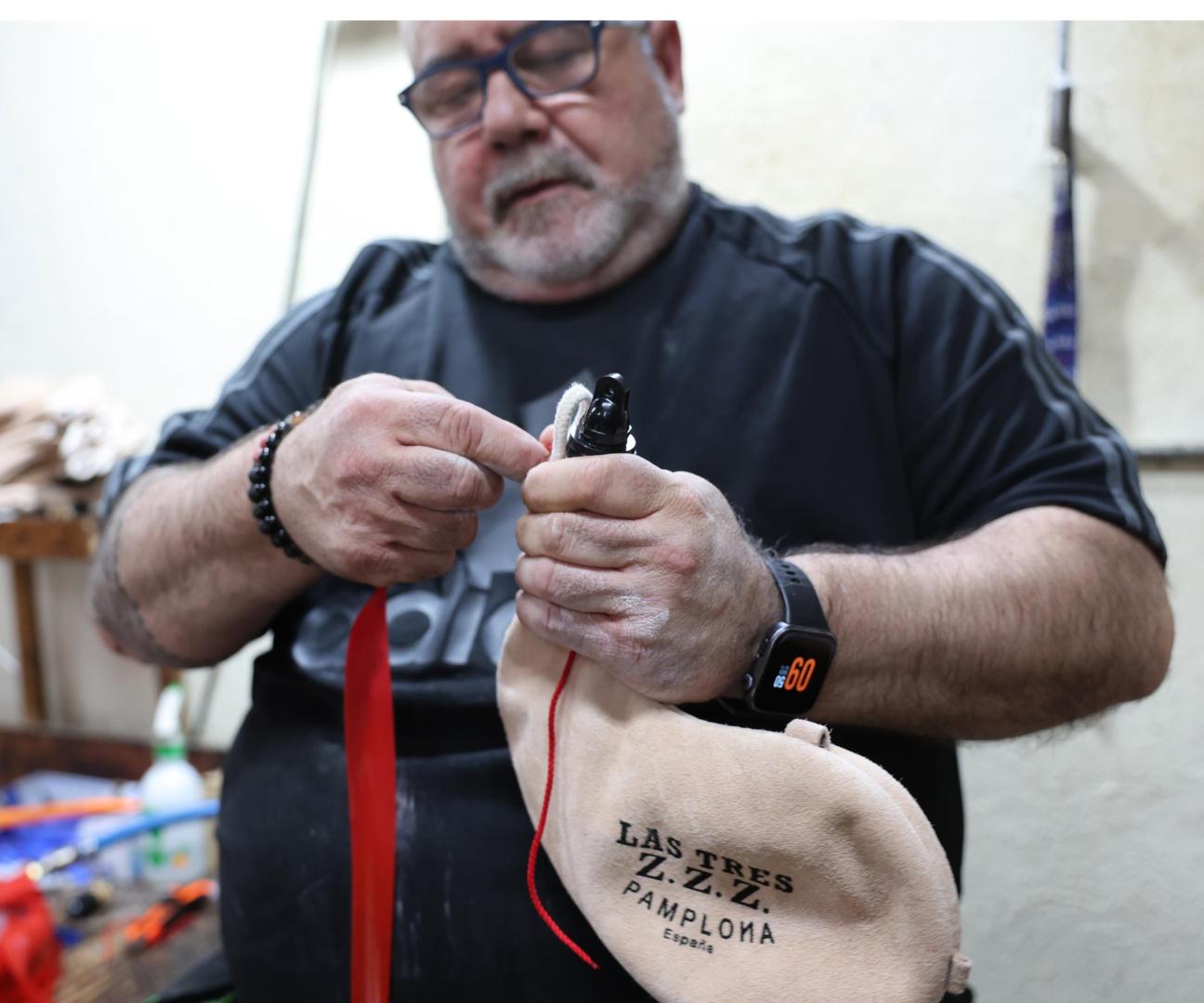 Enrique Mendaza sujeta el brocal a la boca, uno de los últimos pasos para la producción de las botas de vino de Las Tres ZZZ