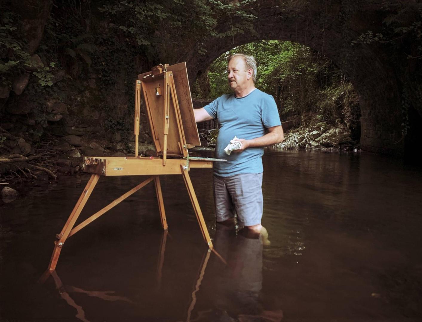 Tomás Sobrino manos a la obra pinta metido en el agua, bajo el puente del molino de Elbete