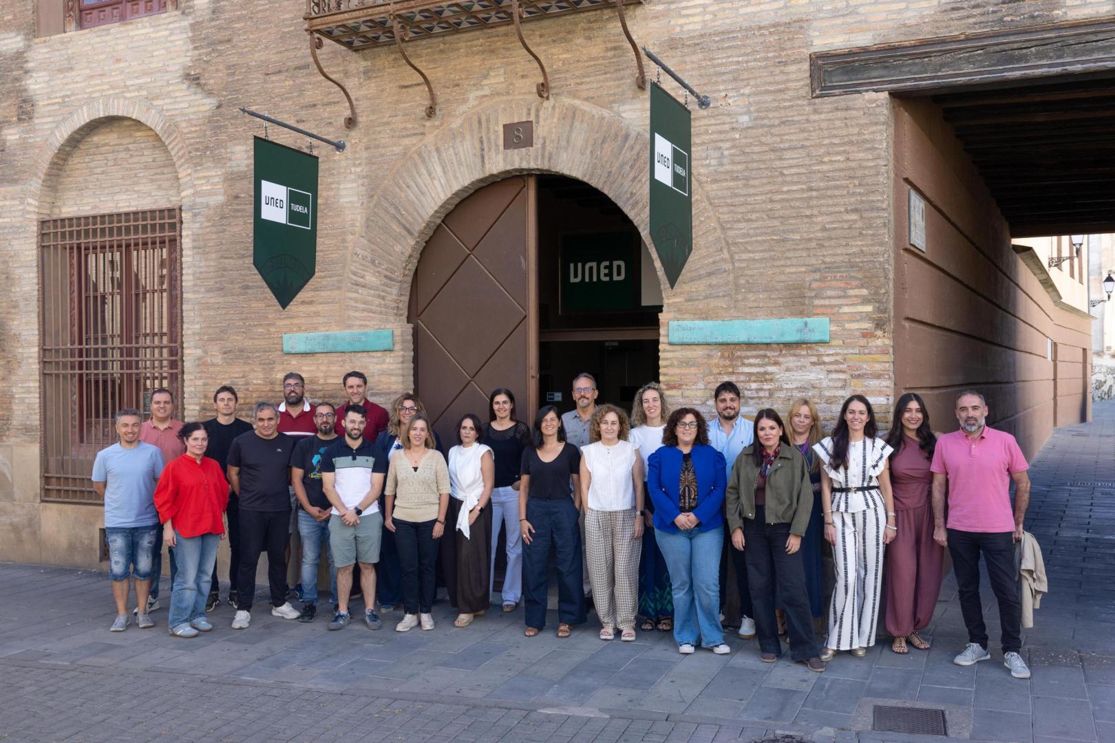 El centro asociado de la UNED de Tudela cuenta con 26 integrantes en su Personal Técnico, de Gestión y de Administración y Servicios (PTGAS) y un claustro de profesorado tutor formado por 45 docentes. En la imagen, y ante la puerta de acceso a la sede de UNED Tudela, algunos de los integrantes de la plantilla -de izda. a dcha.-: Álvaro Prieto Lauroba, Alfredo Melero Gómez, Susana García Romanos, Emilio Jesús Cepeda García, Jesús Baquedano Bruna, José Antonio González Ezpeleta, Luis Elía Fonseca, Adrián Isla Gil, José Manuel Ortega Muruzábal, Ana Carmen Iturre Ibiricu, Concepción Gómez López, Belén Pérez Mayor, Mónica Fernández Hornedo, Sonia Lara Pina, Luis J. Fernández Rodríguez, Ruth Arrechea Enériz, Pilar Escolán Castán, Alicia Hernández Tabuenca, Asier Gil Puyo, Laura Marín Malo, María Ser Romero Orradre, Eva Marín Góngora, Estefanía Morales Ramírez, y Santiago Riega Zoco