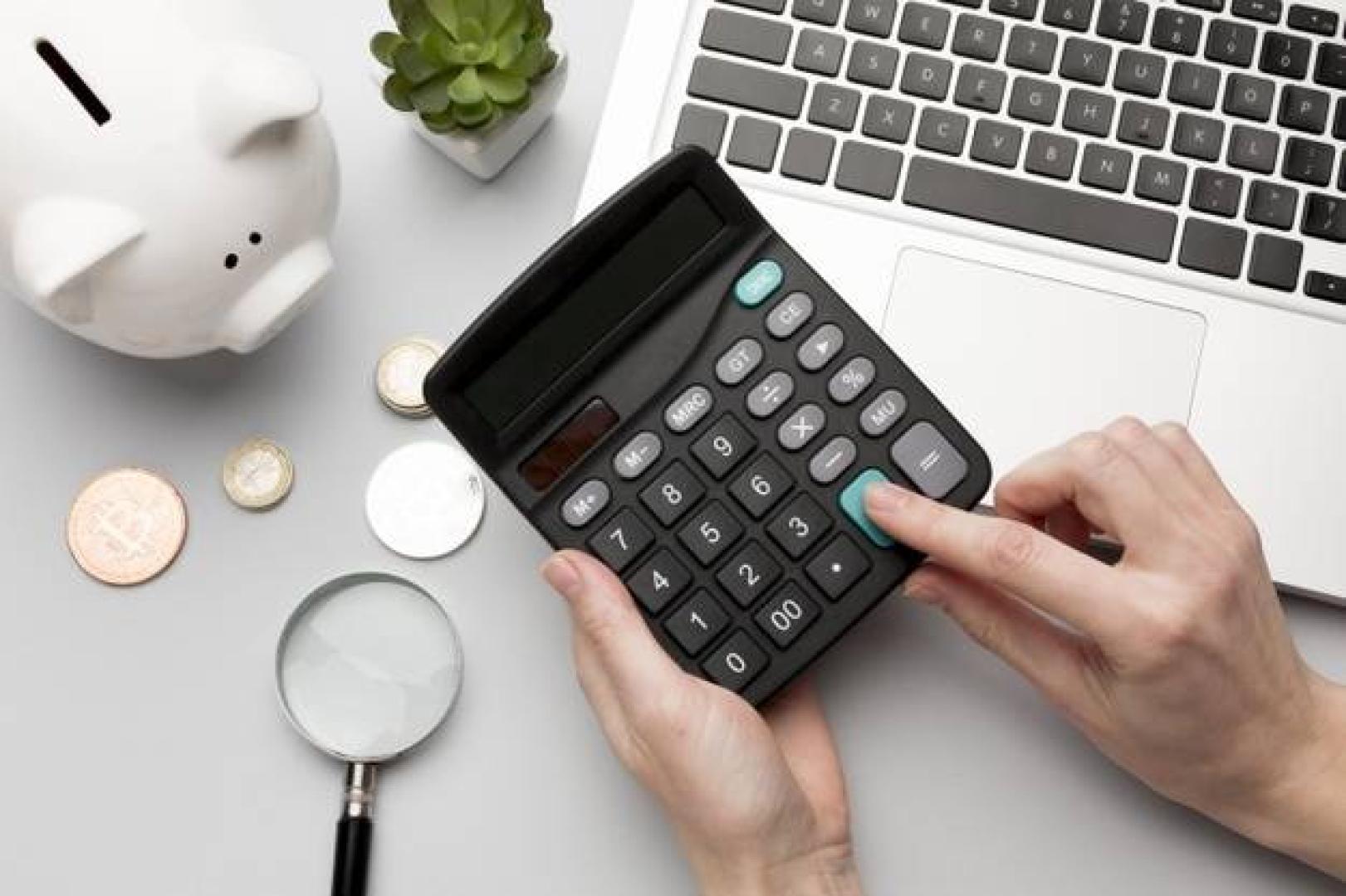 Imagen de una calculadora junto a una hucha