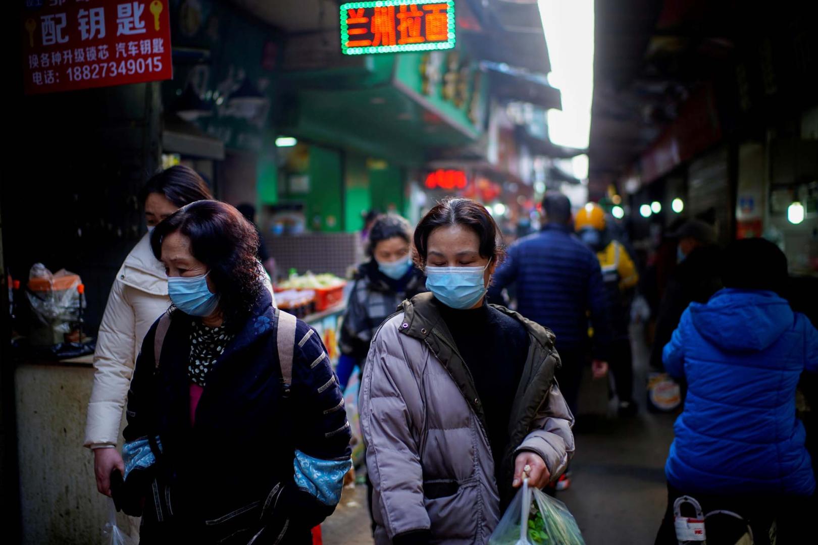 Varias personas caminan por las calles de Wuhan