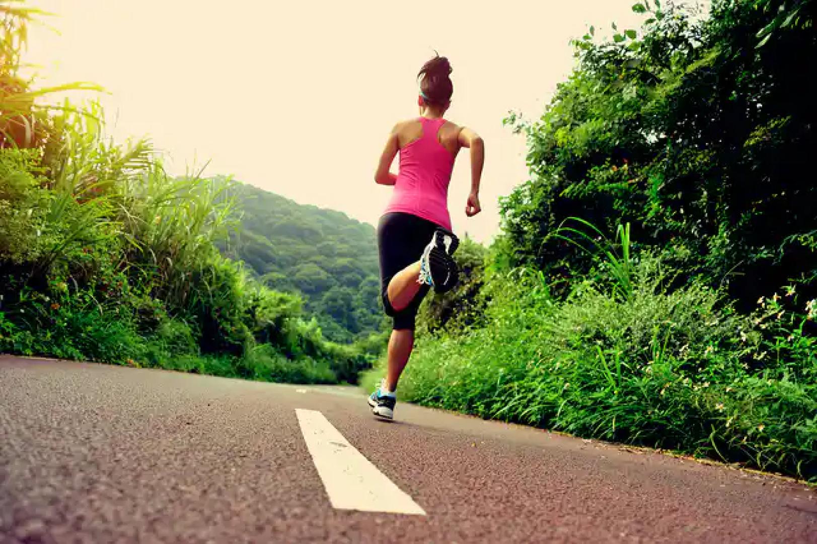 Una mujer, corriendo en una carretera