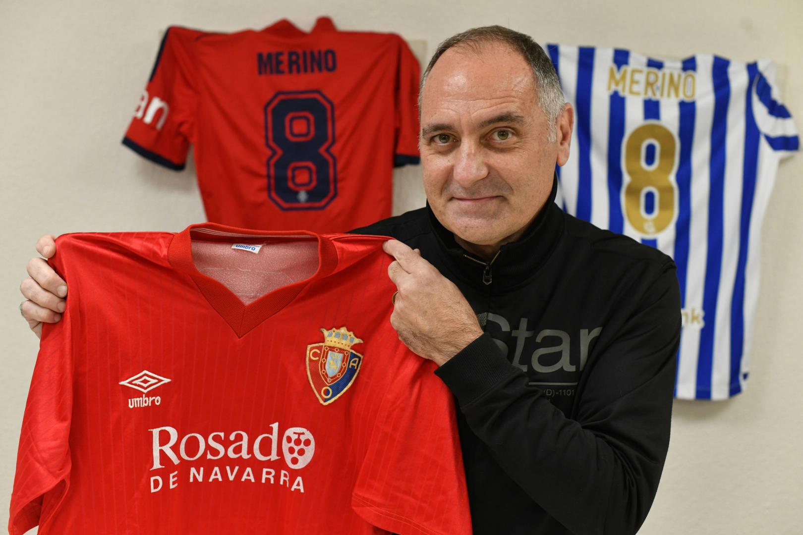 Miguel Merino, con una camiseta rojilla de su época. Detrás, las de su hijo Mikel en Osasuna y la Real